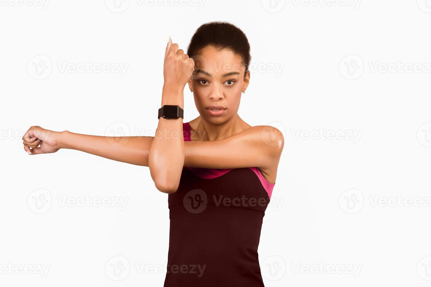 Determined Black Lady Exercising Doing Deltoid Arm Stretch Over White Background In Studio. Workout And Sporty Lifestyle photo