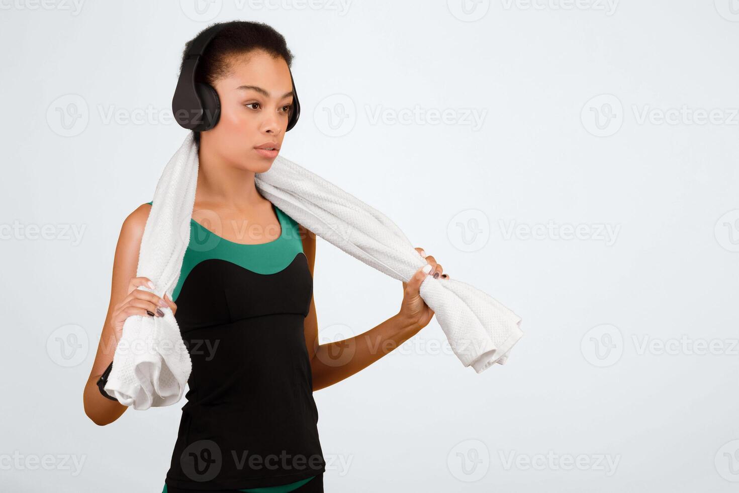 Workout Music Concept. Determined Afro Woman In Headphones Listening To Song Standing On Yellow Background. Free Space For Text photo