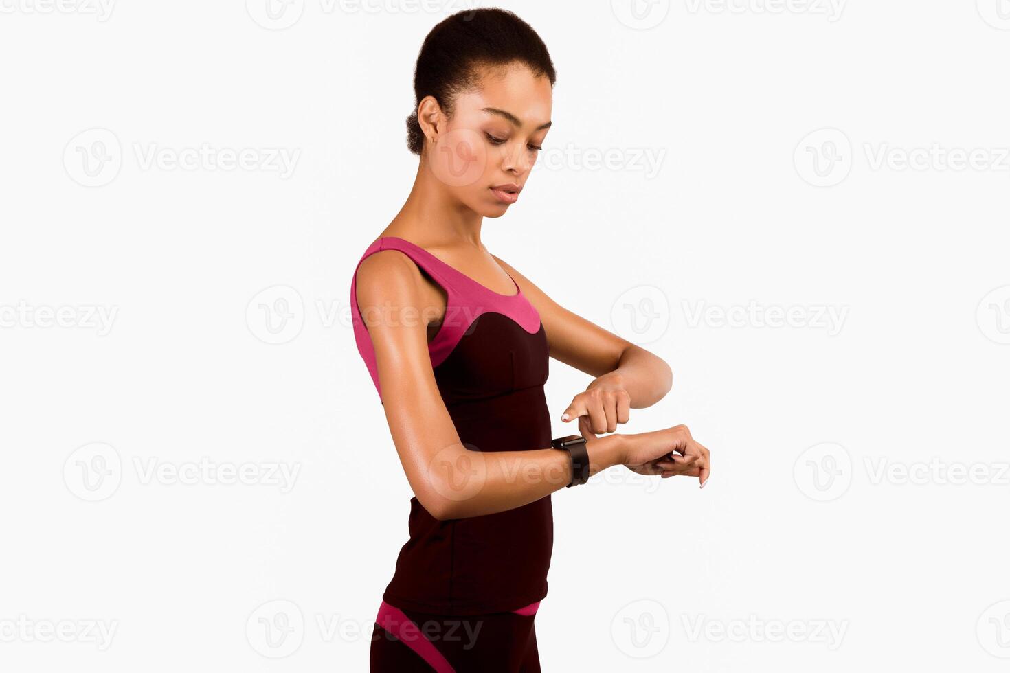 Fitness Tracker. Sporty Afro Girl Using Smartwatch During Workout Standing On White Background. Studio Shot, Isolated photo