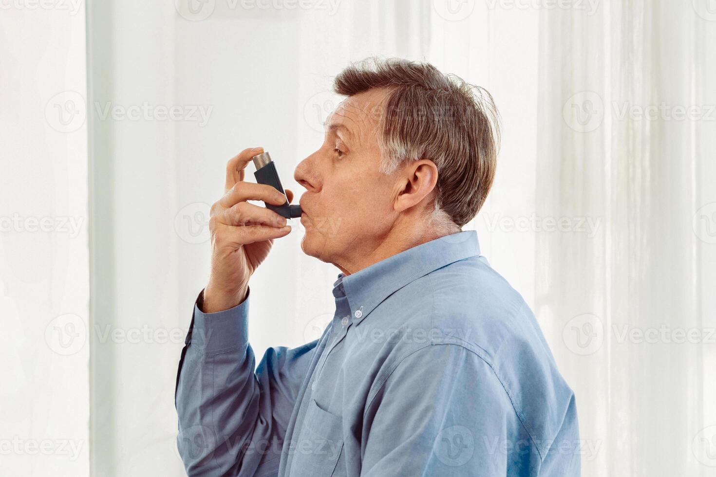 Medical Advice. Elderly man using asthma inhaler, mexican doctor watching, free space photo