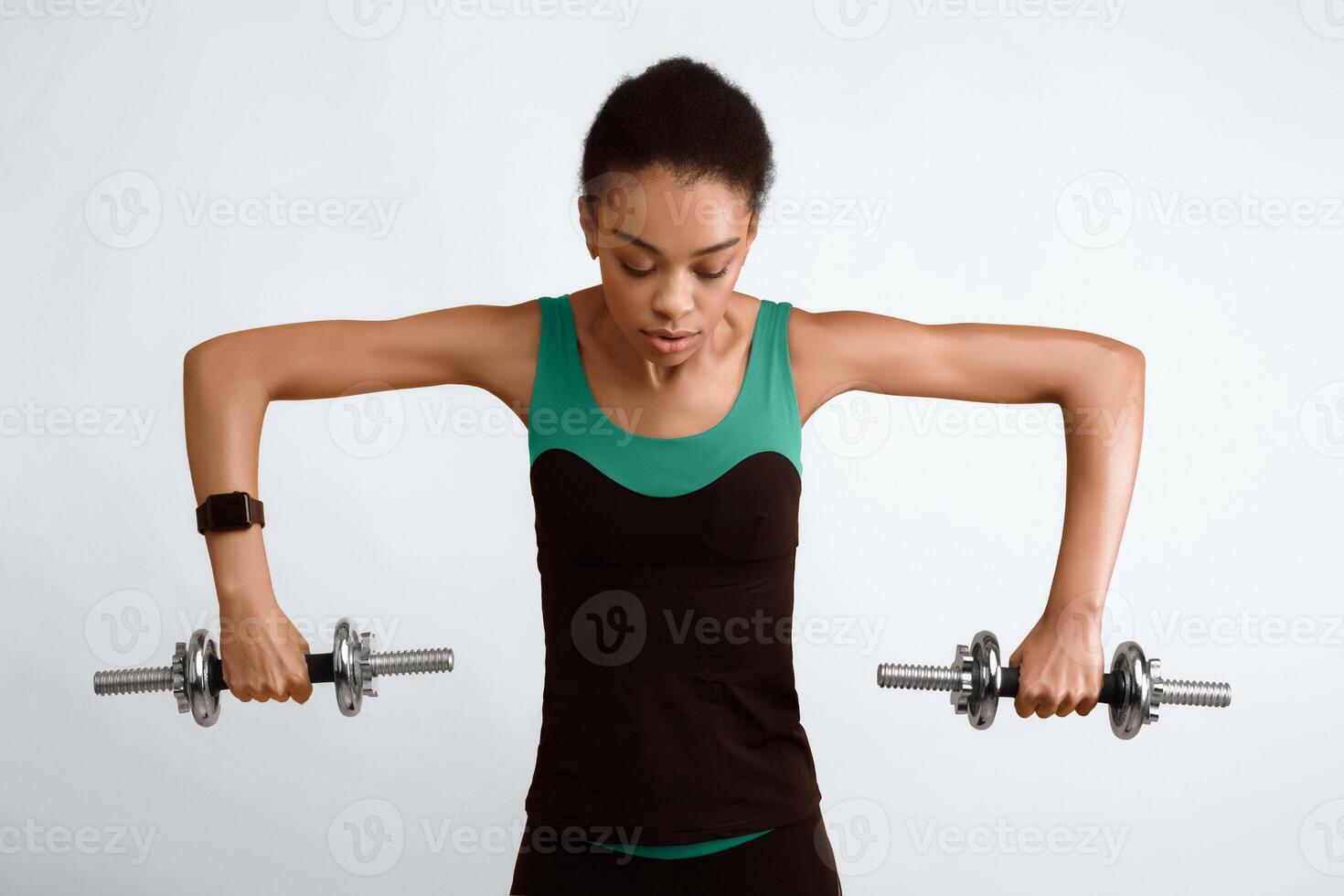 Workout. Sporty African American Woman Doing Dumbbell Exercise Pumping Biceps Over Yellow Studio Background photo