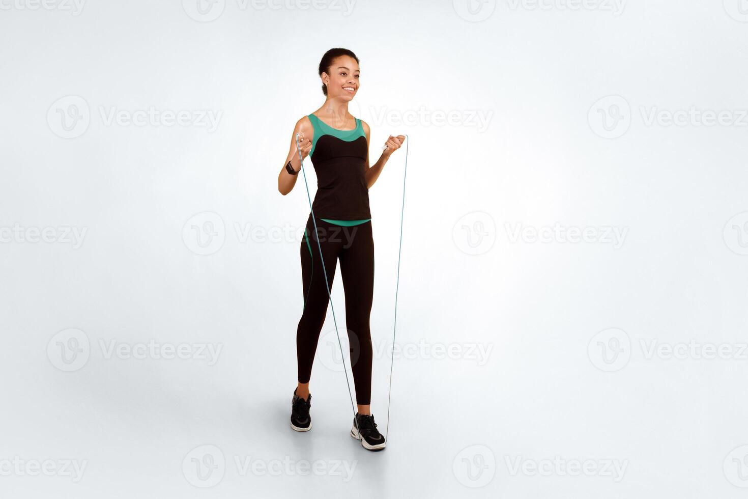 Happy African American Girl Exercising With Jump Skip Rope Over Yellow Studio Background. Full Length, Free Space For Text photo