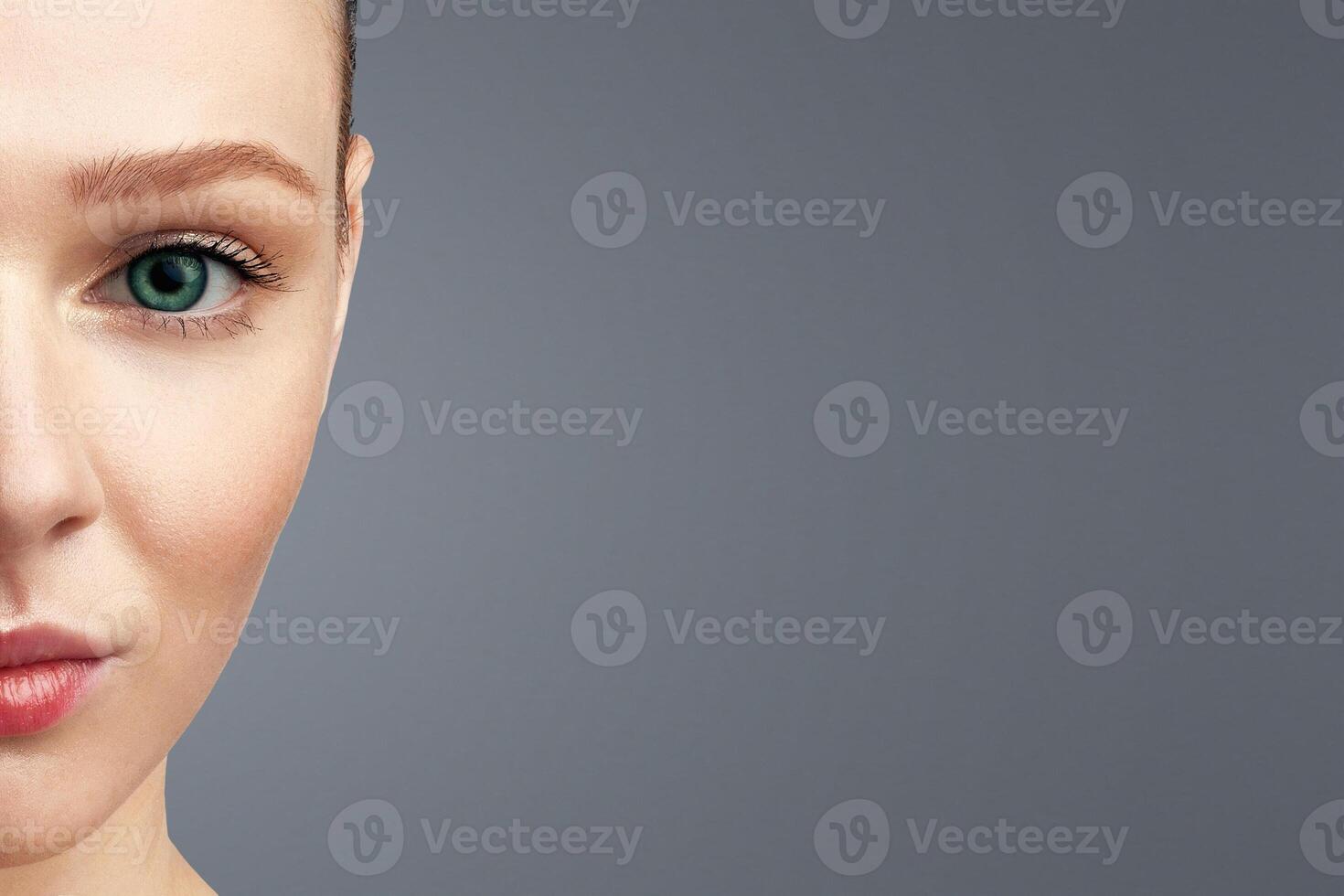 Red-Haired Young Woman Holding White Poster Covering Half Of Face Posing Looking At Camera Standing Over White Studio Background. Female Beauty Portrait With Copy Space photo