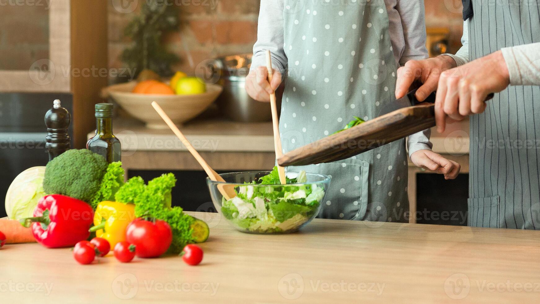 Family Cooking. Cheerful Dad And Little Daughter Preparing Healthy Lunch Together, Adding Vegetables To Salad, Caring Father Teaching Cute Girl How To Cook, Having Fun At Home Together, Copy Space photo