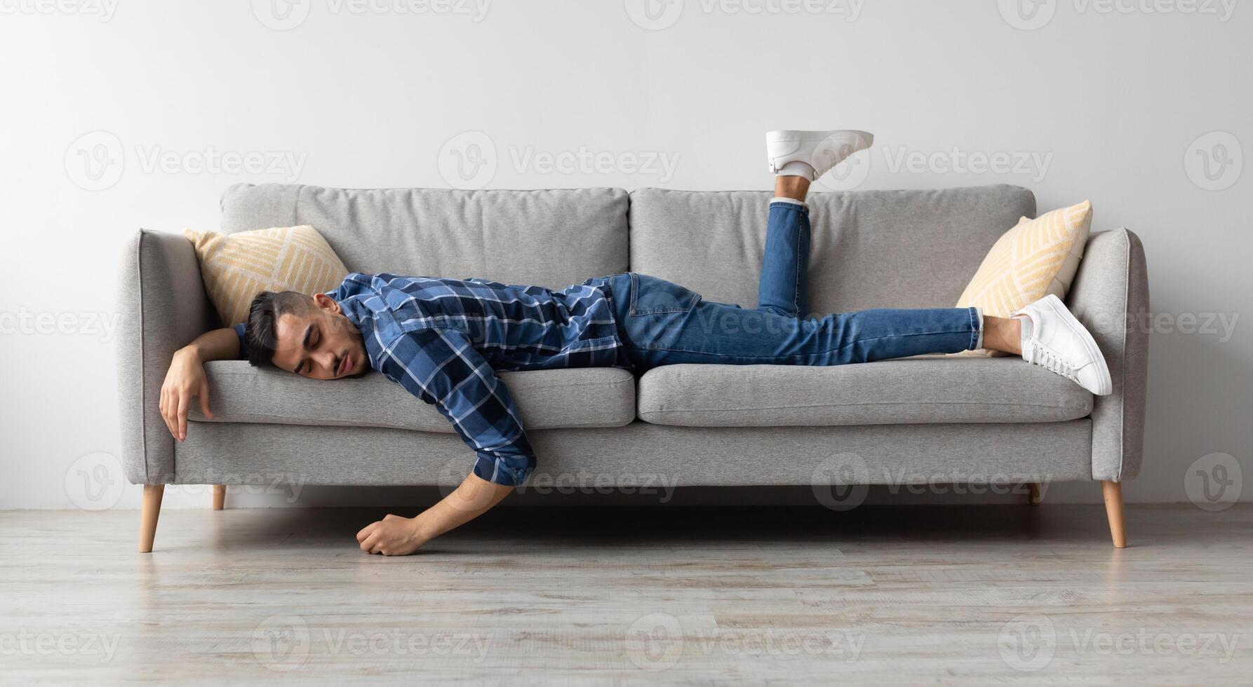 Lack of Energy Concept. Full Body Length Of Exhausted Sleepless Young Man Lying On The Couch With Face Down, Tired In The End Of Hard Working Day, Fatigued Middle Eastern Male Resting At Home photo