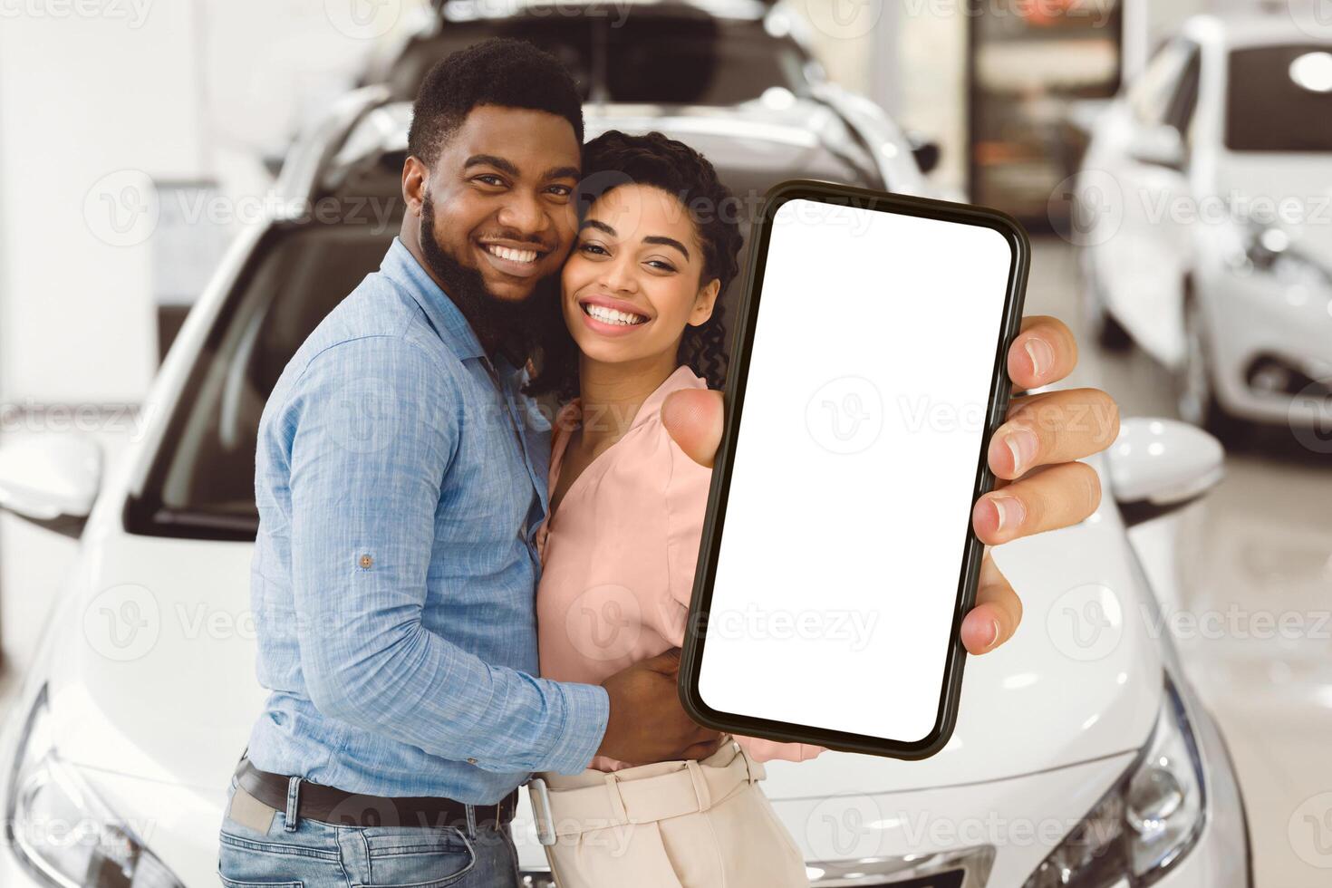 New Automobile. Cheerful Spouses Posing Hugging And Holding New Car Key In Dealership Showroom. photo