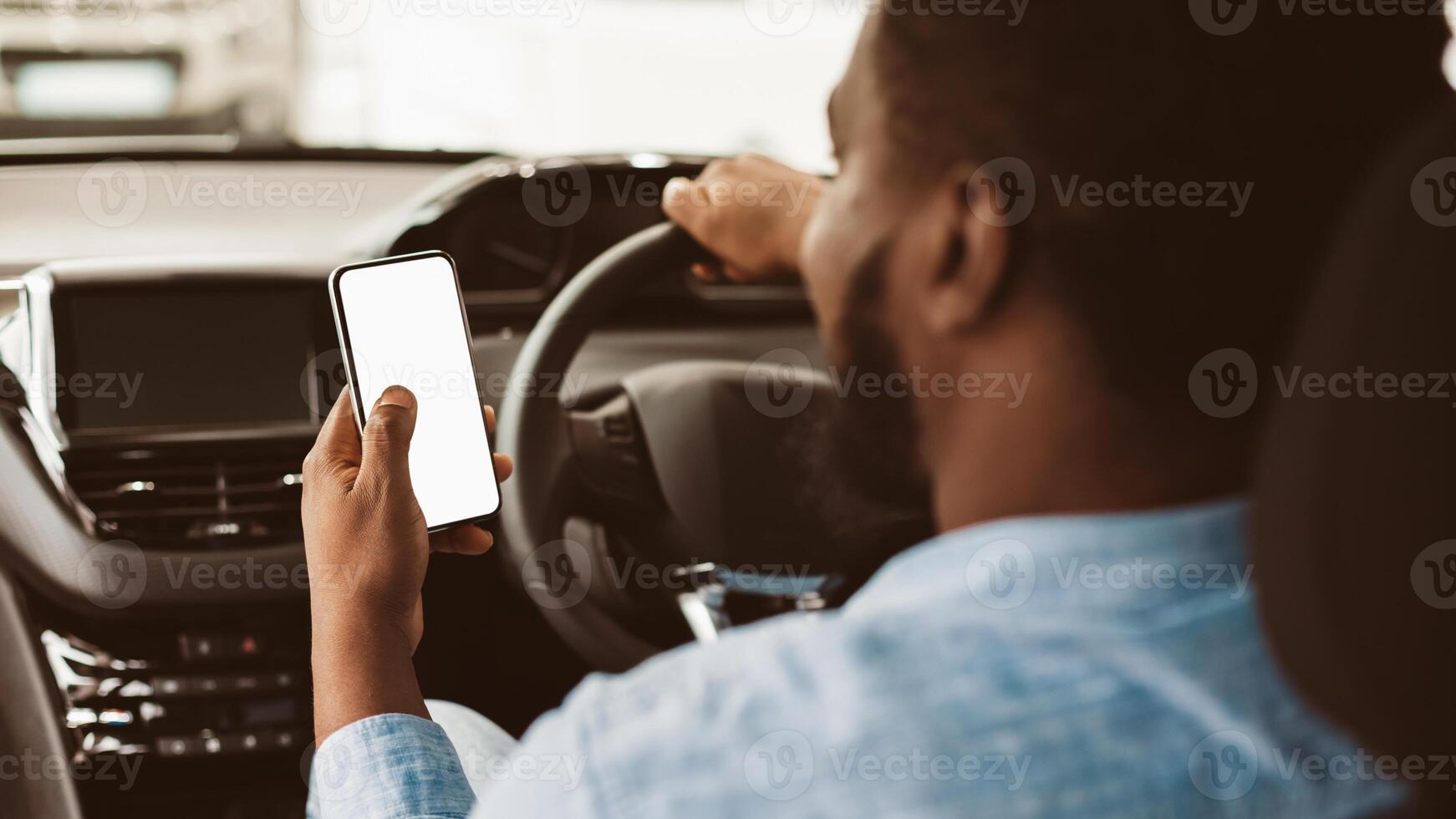 Car Navigation App. Unrecognizable Black Driver Guy Using Mobile Phone With Blank Screen Sitting In Automobile. Selective Focus, Mockup photo