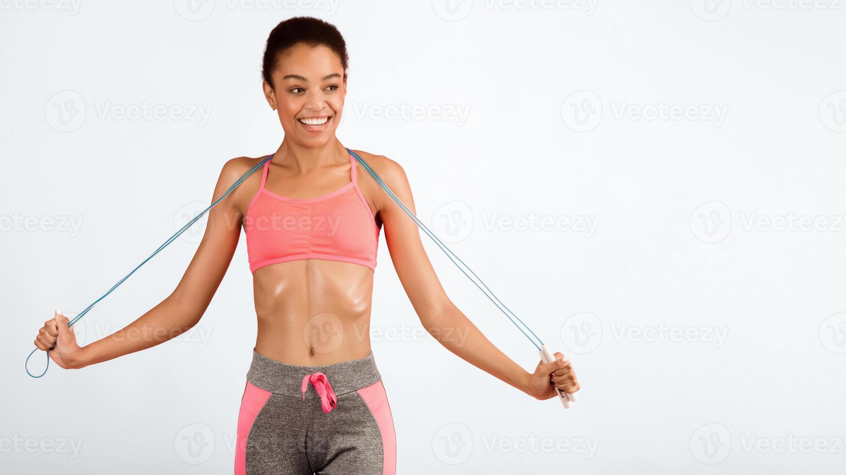 Cheerful Fitness African American Lady Holding Jump Rope Smiling Posing On Pink Background In Studio. Panorama, Free Space photo