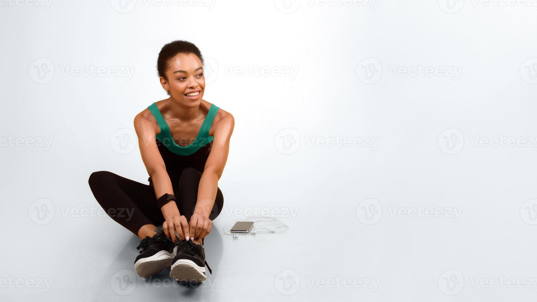 Fitness Lifestyle Concept. Afro Woman In Fitwear Sitting On Floor Ready For Workout Over Yellow Studio Background. Panorama, Empty Space photo