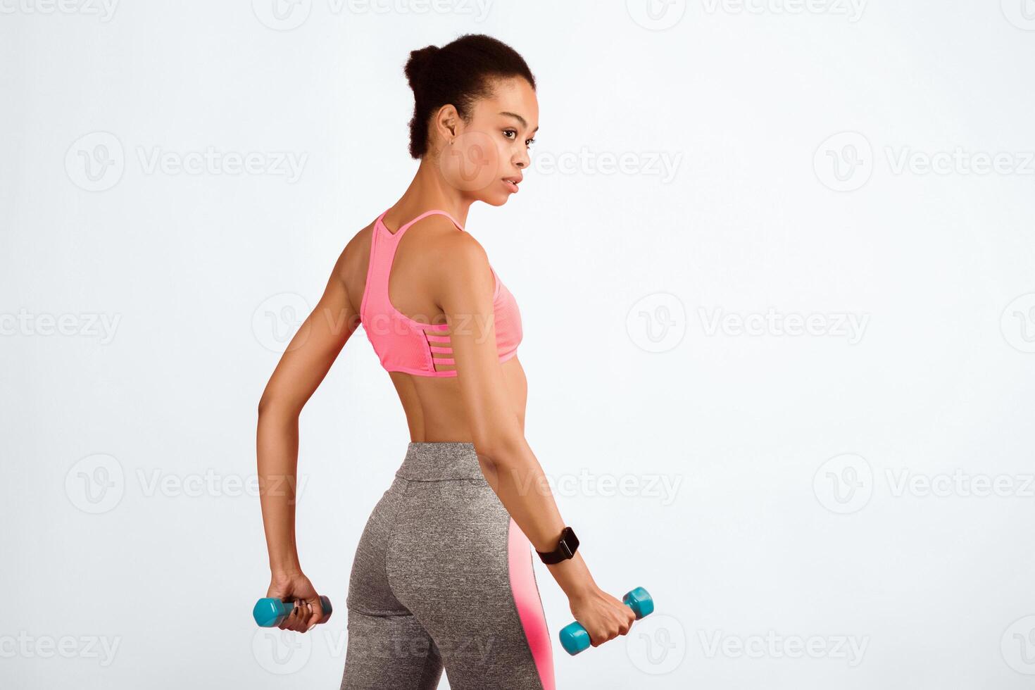 Workout. Motivated Black Lady Exercising With Dumbbells Over Pink Studio Background. Copy Space photo