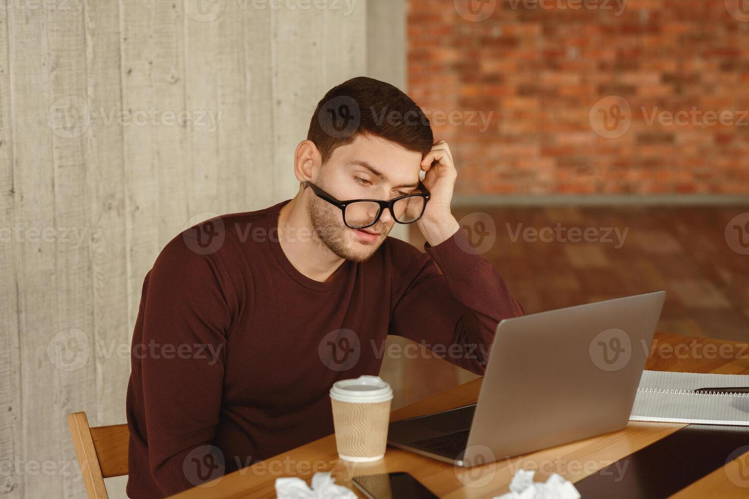 Workaholism. Overworked Guy Sleeping At Workplace Sitting At Laptop In Modern Office. Selective Focus photo