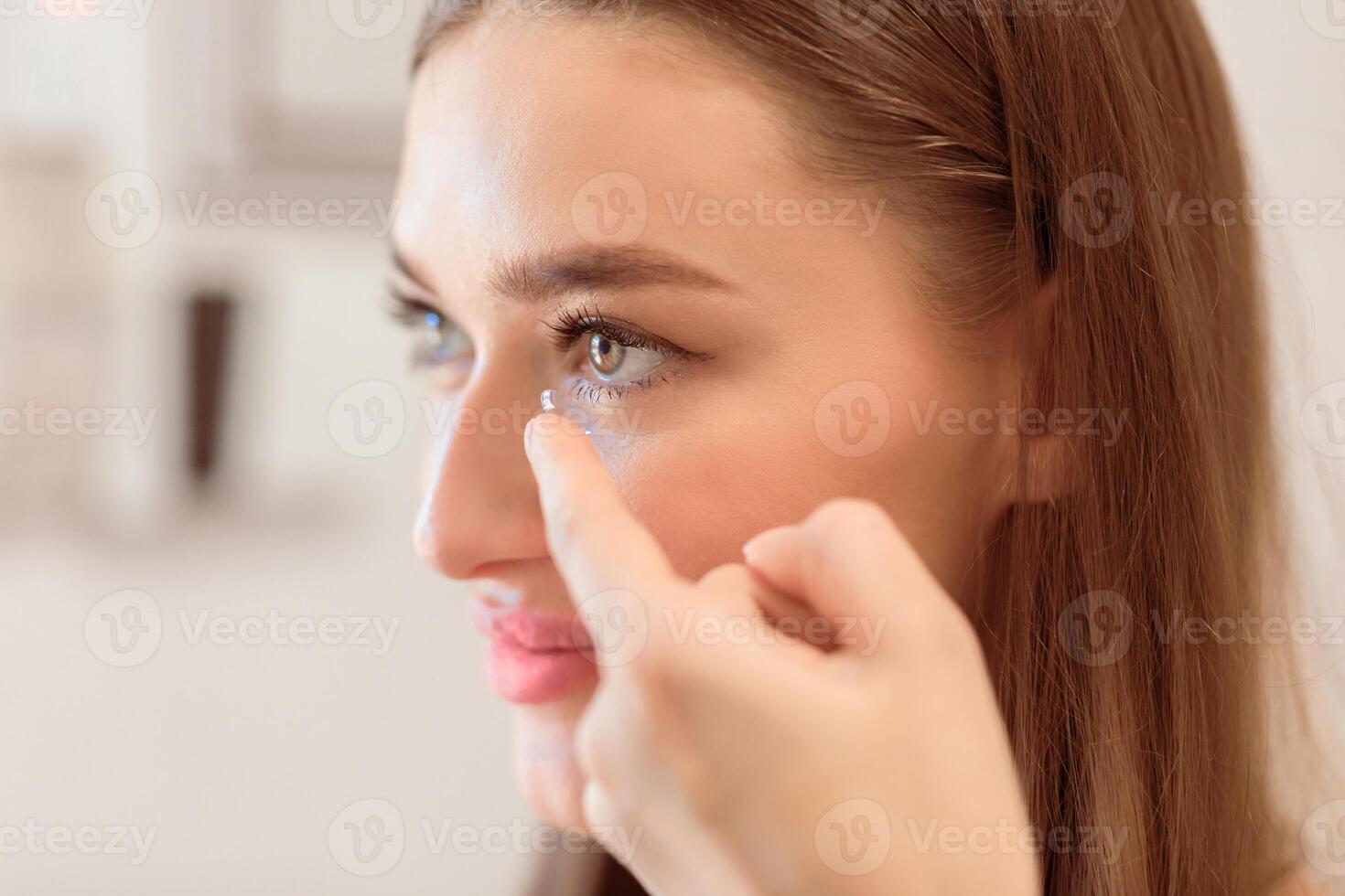 Contact Lens For Vision Concept. Close up side view portrait of smiling woman applying eye lens photo