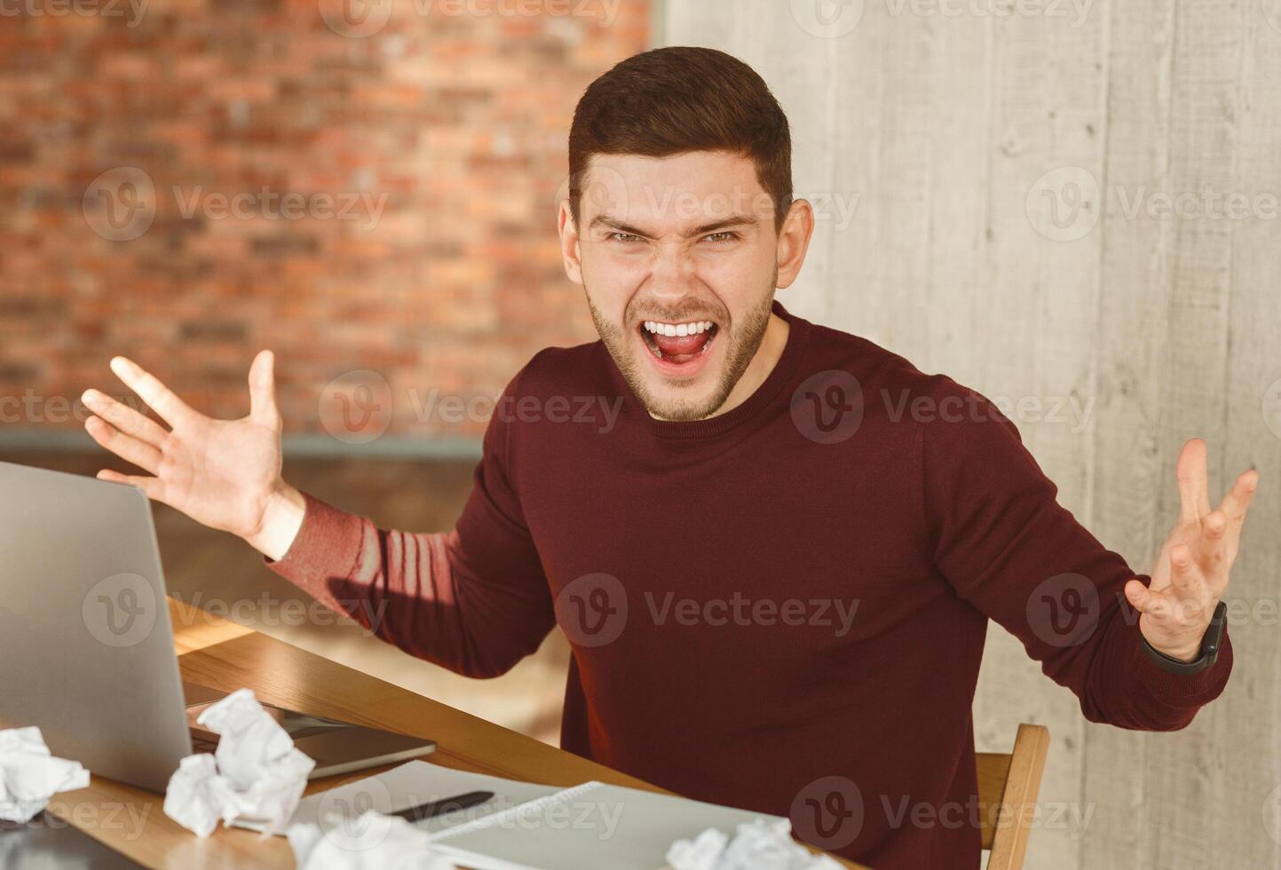 Job Stress. Crazy Man Shouting And Gesturing Having Nervous Breakdown At Work In Office. Selective Focus photo