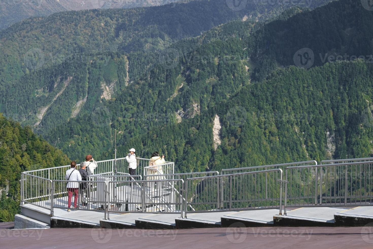 Kurobedaira Station, Tateyama, Toyama, Chubu, Japan, A scenic observation deck with visitors overlooking lush green mountains and valleys photo