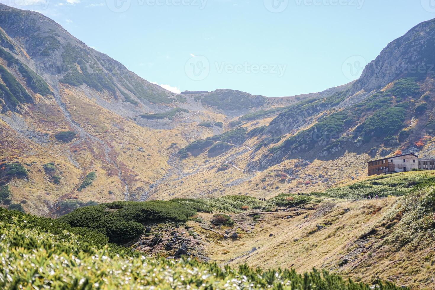 Murodo, Tateyama Kurobe Alpine Route, Japan, A scenic landscape featuring rolling mountains, lush greenery, and a serene sky photo