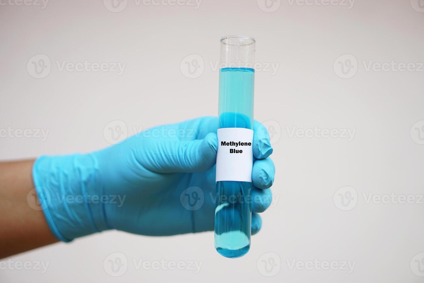 Close up chemist hand wears glove, hold test tube of Methylene Blue. Concept, Chemical used as a dye and as medication for methemoglobinemia treatment. Scientific experiment. Laboratory process. photo