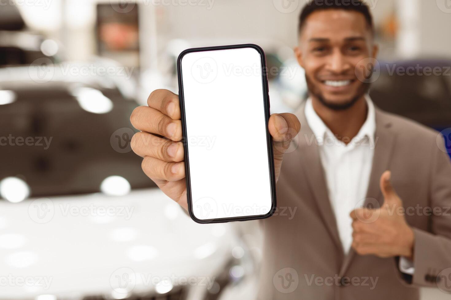 Car Sales. Unrecognizable Manager Guy Showing Key Gesturing Thumbs Up Standing Near Auto In Store. Shallow Depth, Copy Space photo