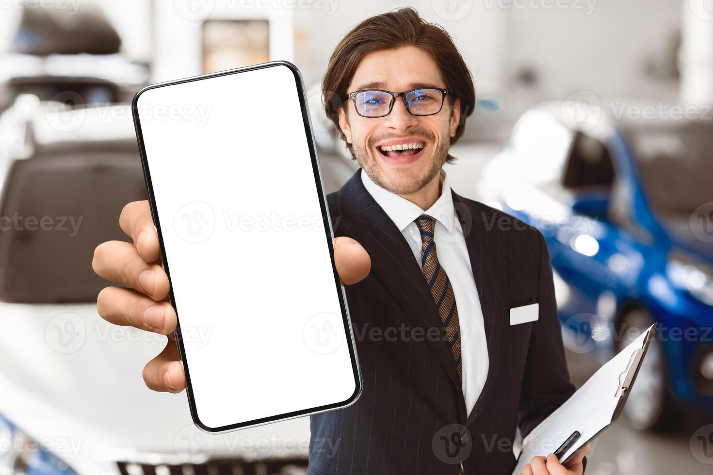 Car Rent. Handsome Agent Showing Auto Key Standing In Automobile Rental Office. Copyspace, Shallow Depth photo