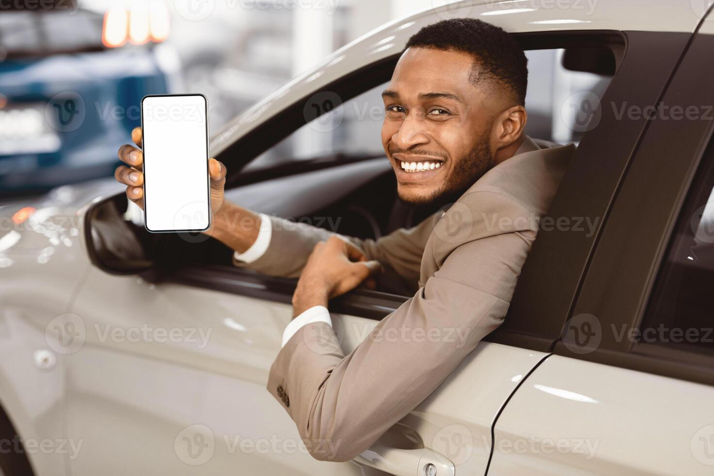Afro Businessman Showing Car Key Sitting In Driver's Seat Smiling To Camera Buying Auto In Dealership Store. Selective Focus photo