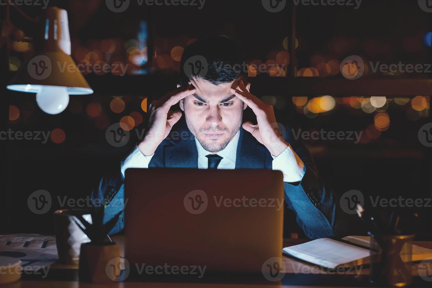 Concentrated Businessman At Laptop Thinking On Business Project Working Overnight In Modern Office. photo