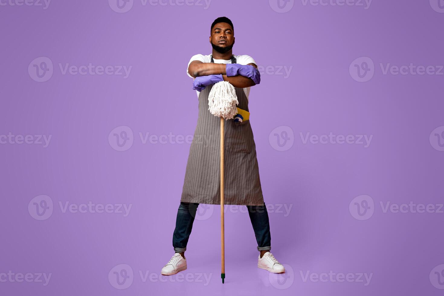 On Guard Of Cleanliness. Professional African American Cleaner Posing With Mop Over Pink Background In Studio, Ready For Big Cleaning photo