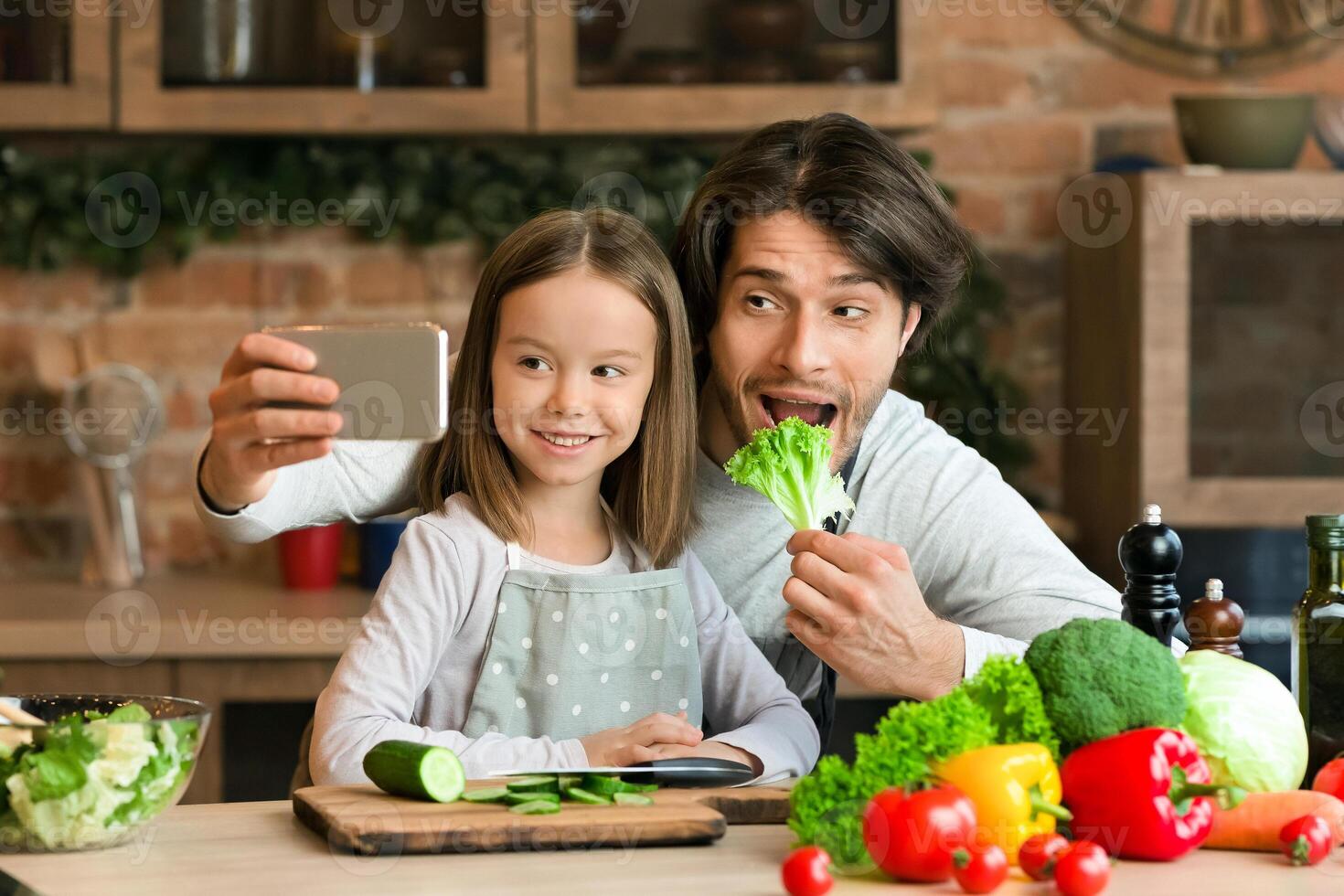 Cooking Selfie. Joyful Young Dad Taking Photo On Smartphone With His Little Daughter In Kitchen While They Preparing Healthy Lunch Together, Panorama