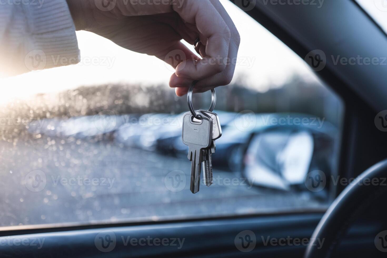Keys dangle from a ring with a parking lot seen through the car window photo
