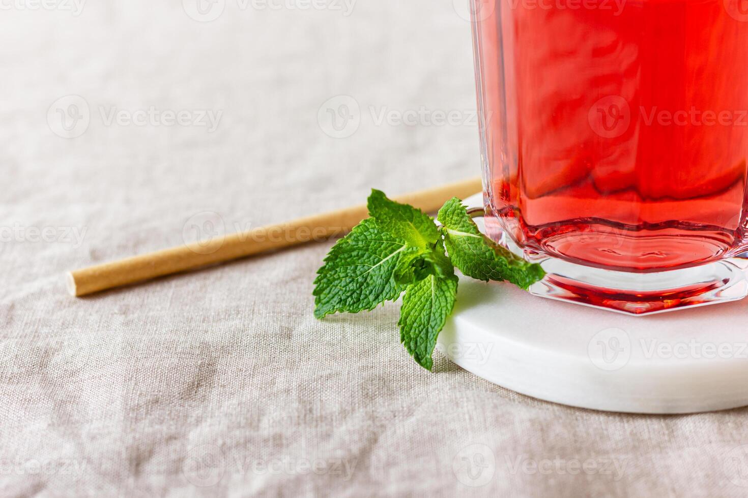 Red berries and fruits drink in the glass on the light background. photo