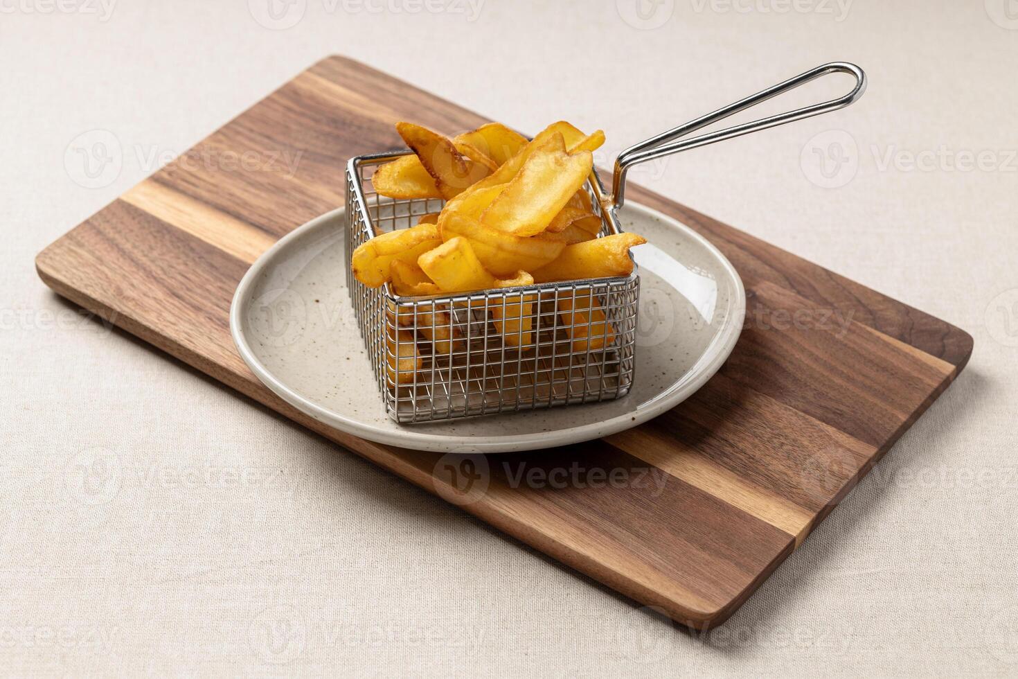 French fries in a metal basket on a wooden board photo
