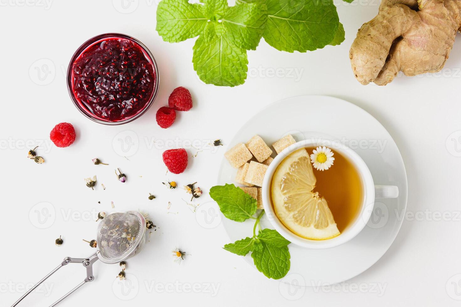 Chamomile tea with mint, raspberry jam and ginger on white background. photo