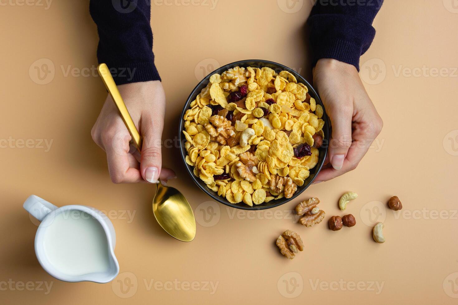 Corn flakes with nuts and milk in bowl photo