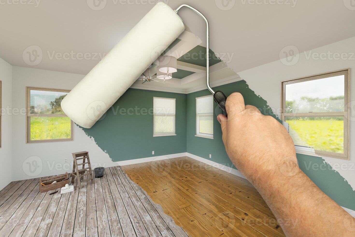 Before and After of Man Using A Paint Roller to Reveal Newly Remodeled Room with Fresh Green Paint, Coffered Ceiling and New Floors. photo