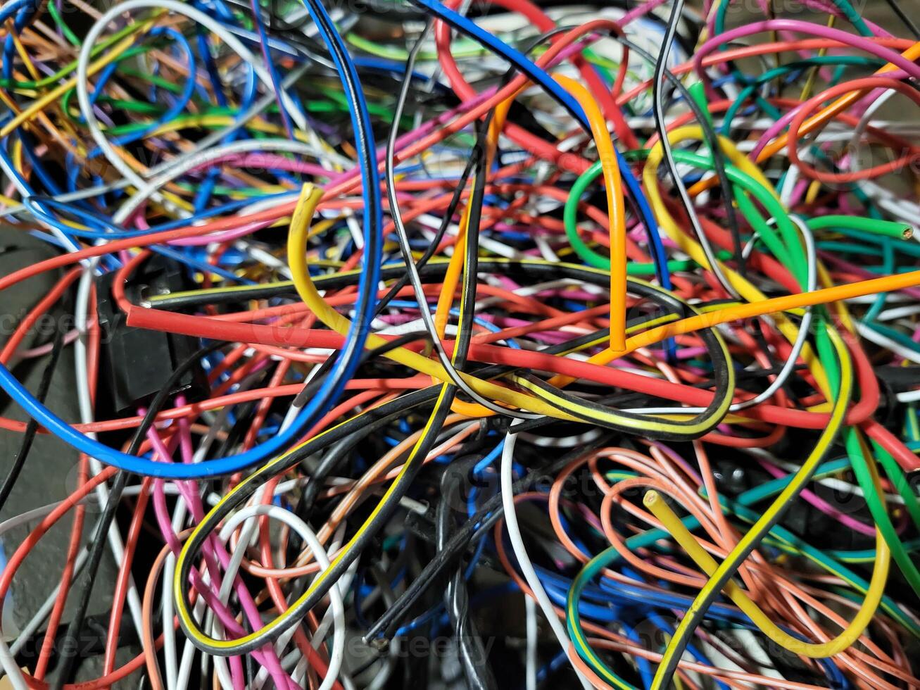 In the garage, after the work of an auto electrician, there are a lot of thin wires, tangled colored wires, intertwined with each other photo