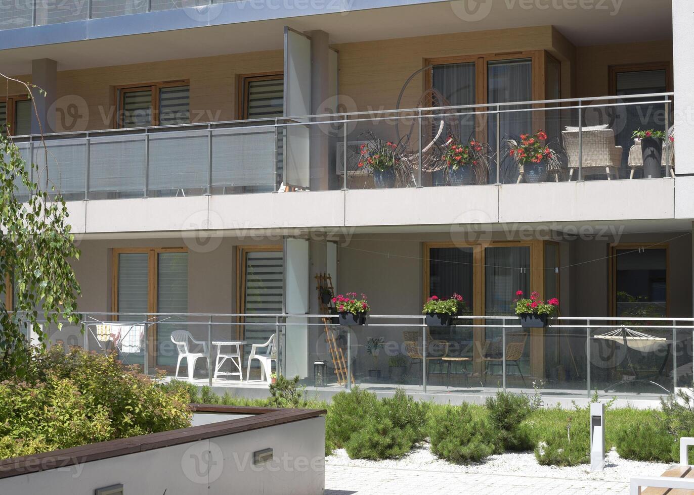 Beautiful European balcony with flowers and a swing chair on it in an apartment building photo