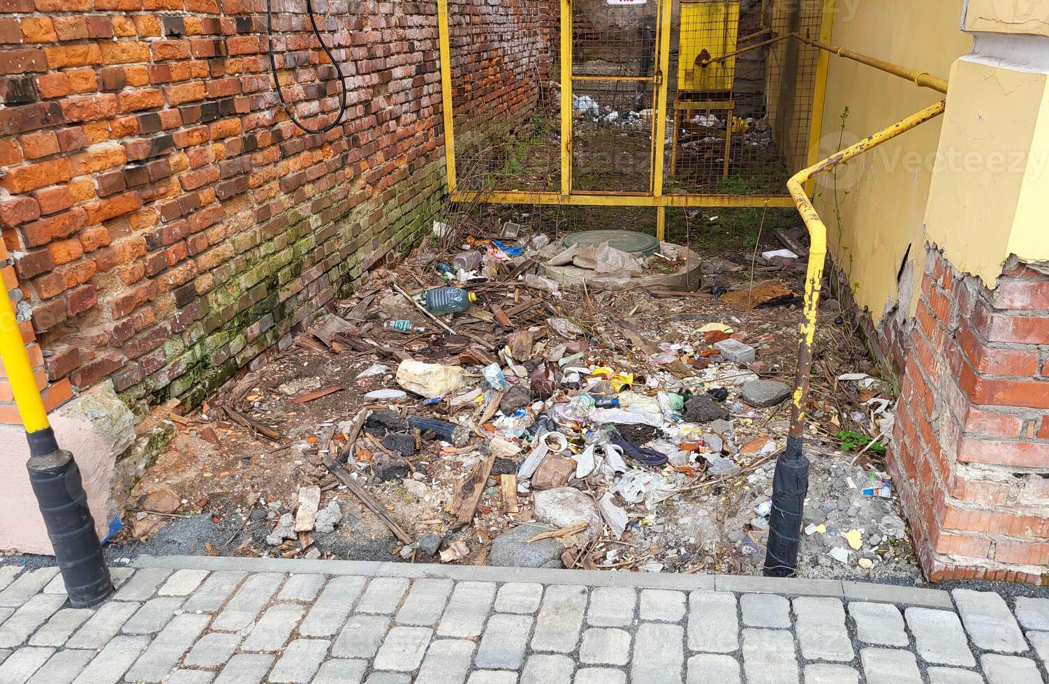 The walls of a brick house. Garbage is lying between the houses. photo