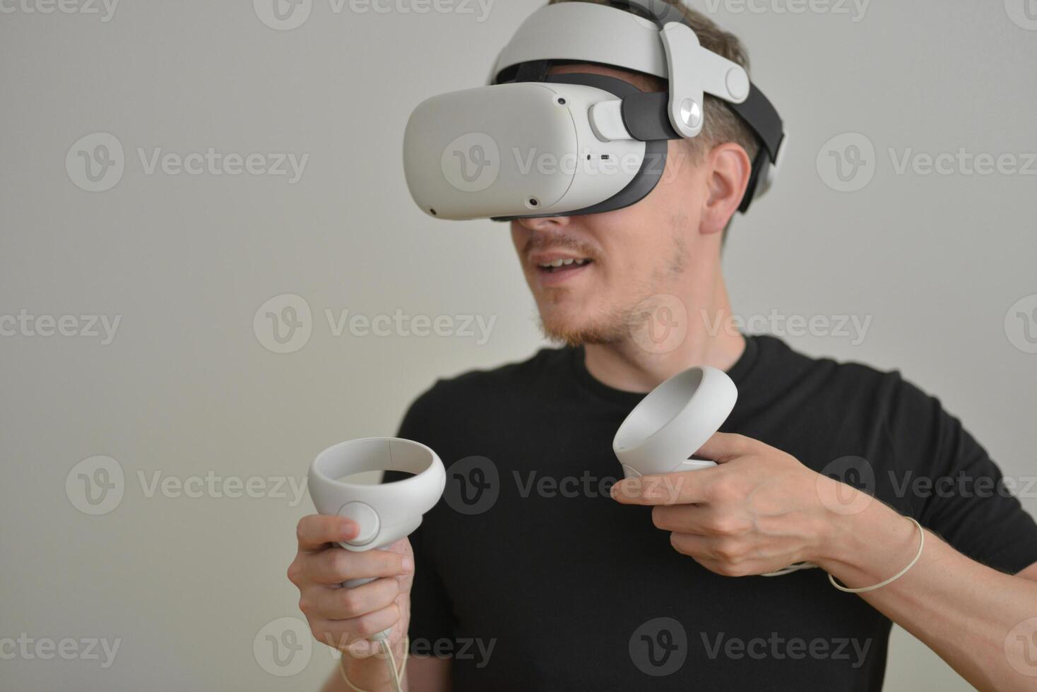 A Young Man Playing using Visual Reality Glasses with Joysticks with Copy Space. VR Headset Goggles Connecting Metaverse. Futuristic Cyberspace Technology, Virtual Digital Environment Concept photo