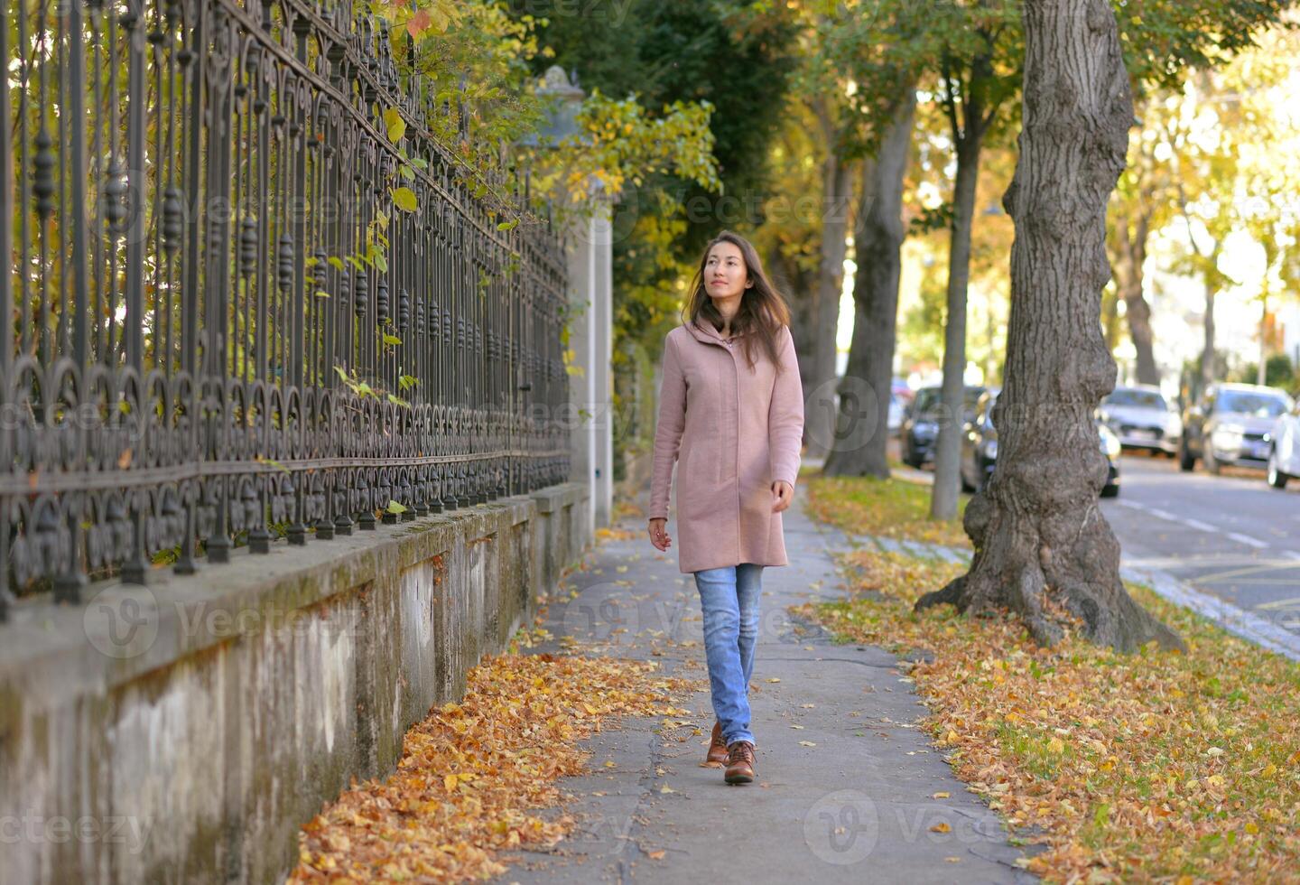 A girl walks along a calm and quiet street on a sunny autumn day in Vienna photo