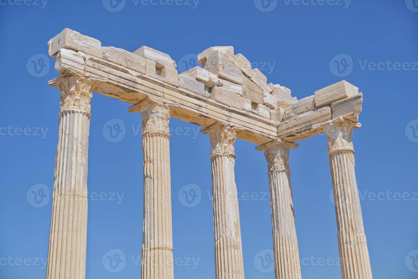 Roman ruins of an ancient city. Columns of a ruined temple of Apollo at the background of sky. Archaeology excavation of Side, Turkey photo
