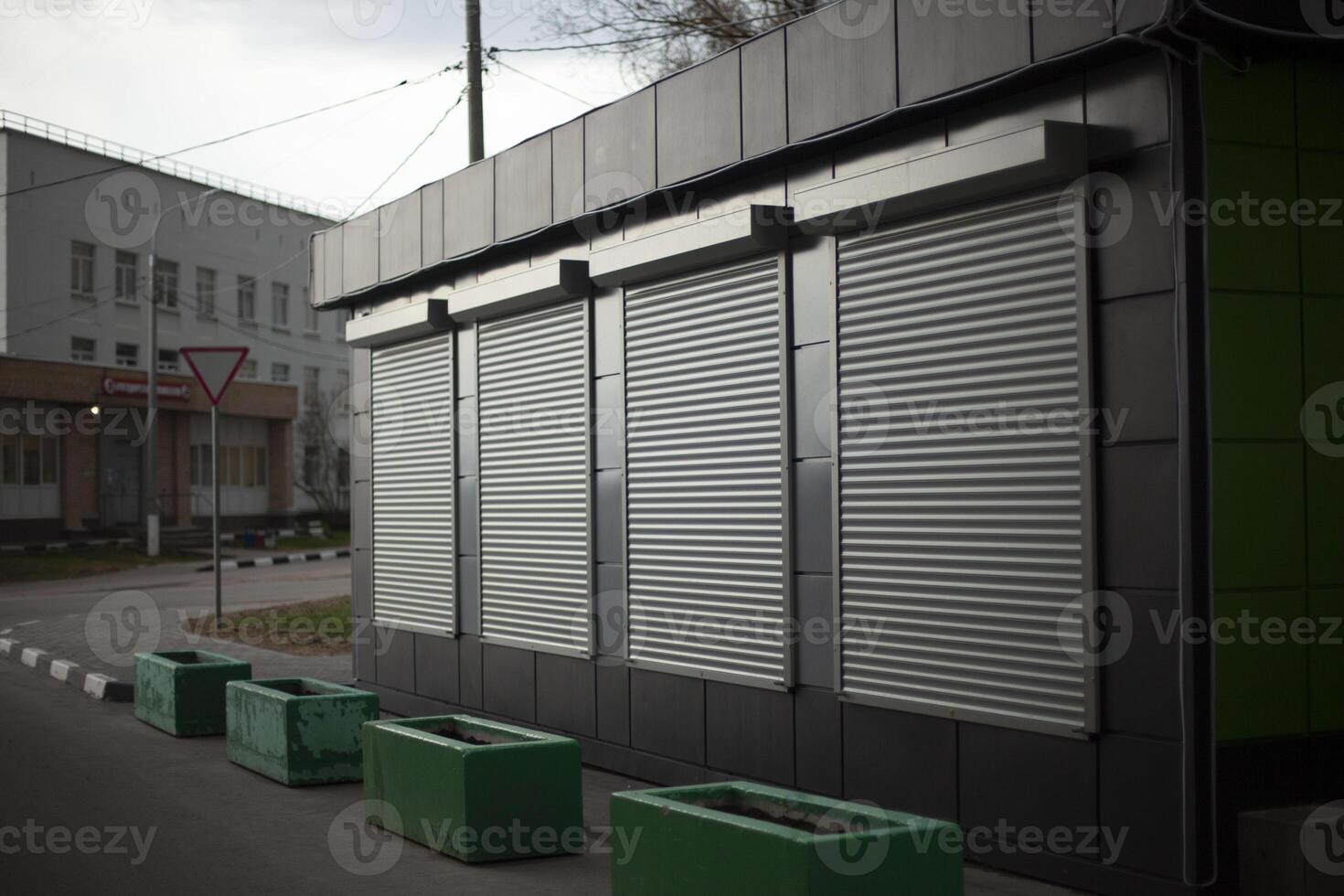 Shutters on windows. One-storey office. Sales building. Blinds are down. photo