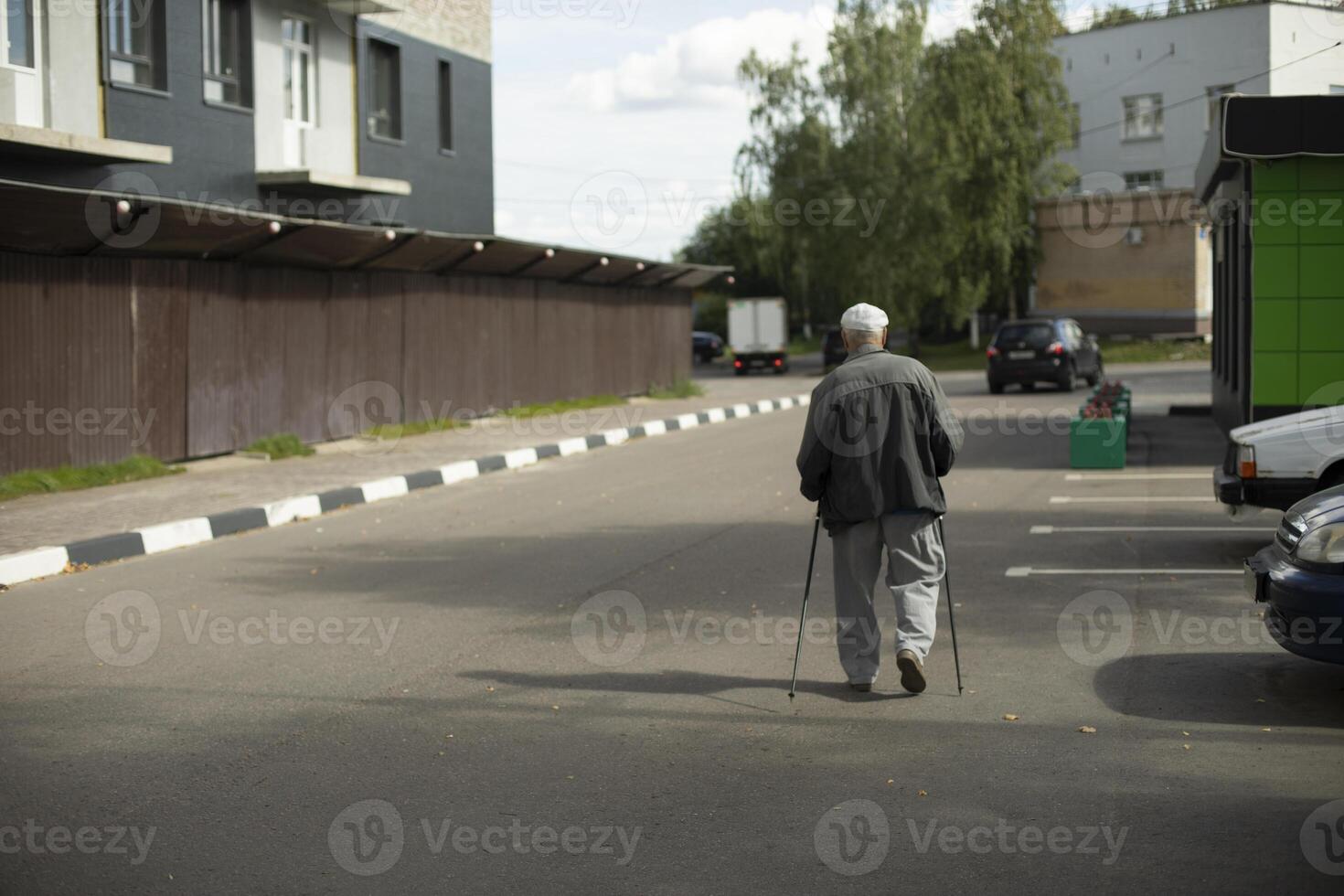Old man with walking poles. The man on the street. Grandpa on a walk in the city. photo