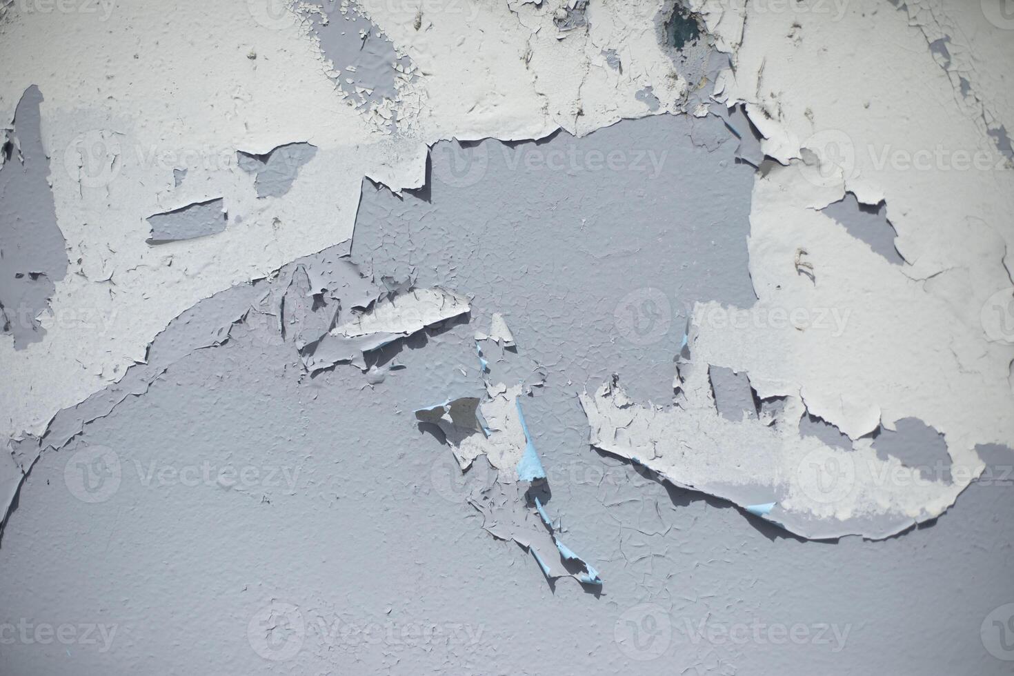 Old paint on gray wall. Flying paint. Ruined background. photo