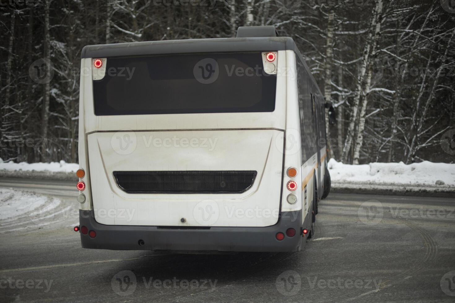 Bus turns in winter on road. Transport on highway. Public transport is unfolding. photo