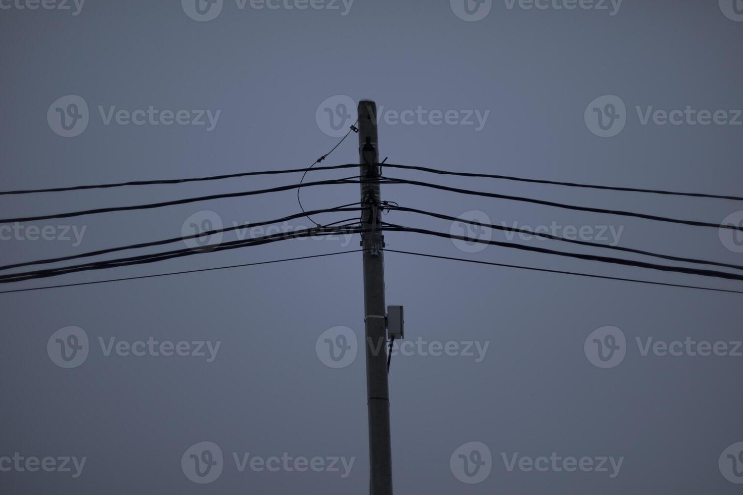 Wires on pole. Electrical wires on background of gray sky. Depressing look. photo