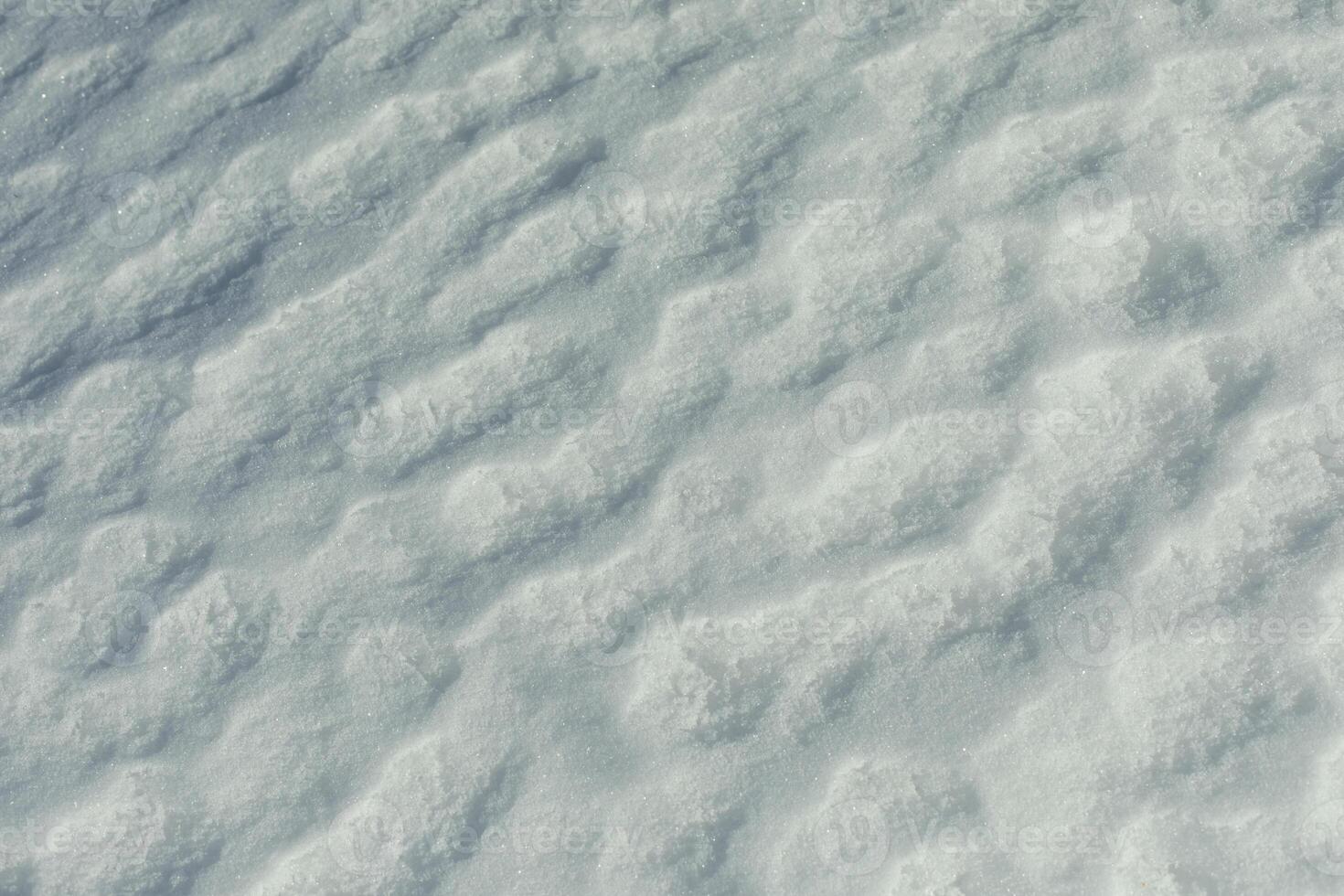 Texture of snow. Melted snow in winter in sun. Surface is wavy. photo
