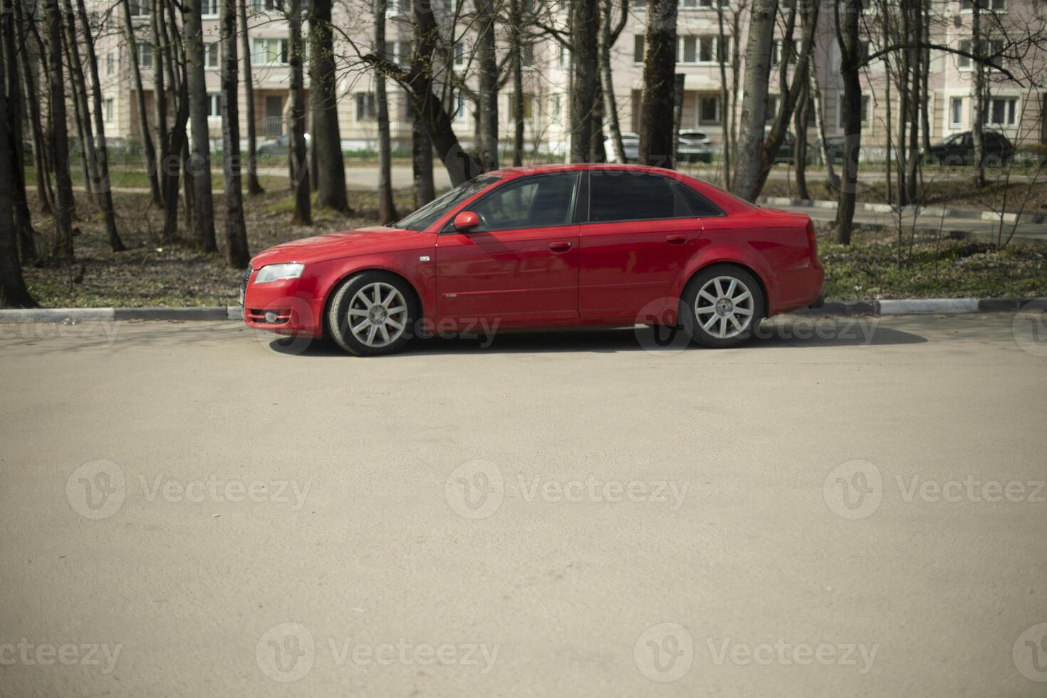 Red car in the parking lot. The car is standing on the asphalt. Transport on the street. photo