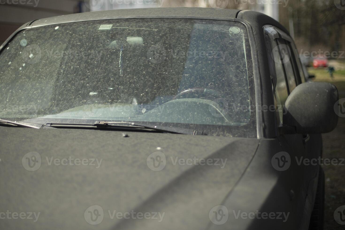 The car is in the dust. Dirt on the body of the vehicle. Black car in the parking lot. photo