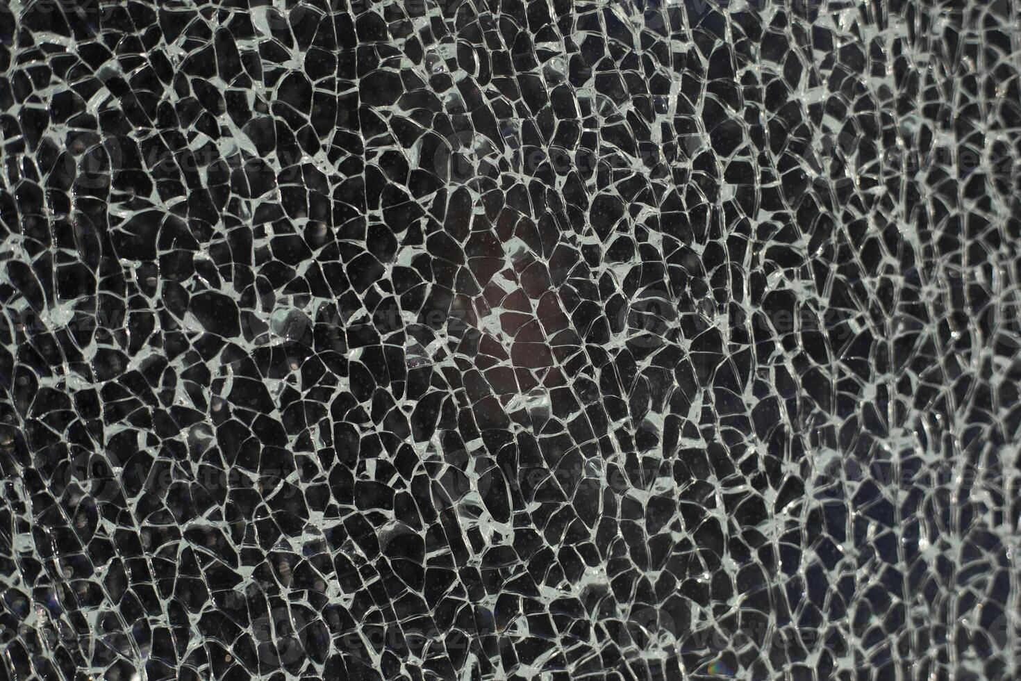 Small cracks on the glass. Texture of broken glass. Lots of chaotic fragments. photo