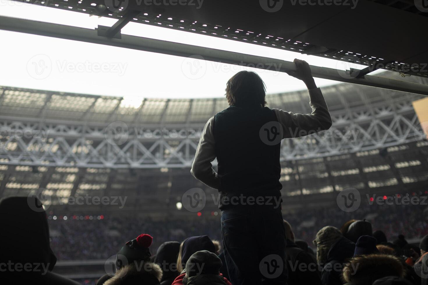 Guy at stadium. Silhouette of man against background of stadium. Mass event and one person. photo