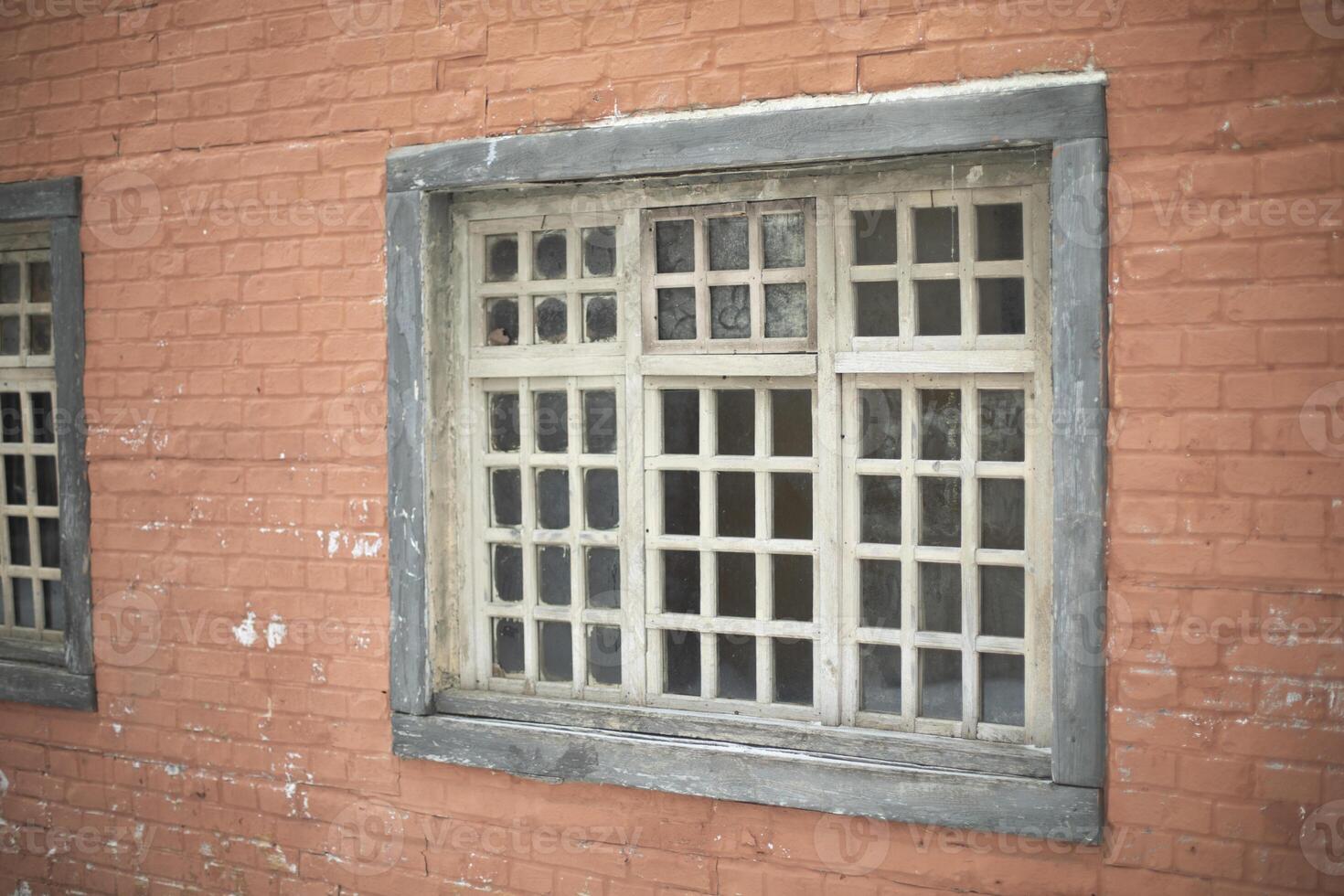 Window with grille in wall. Old window. Wall of house. photo