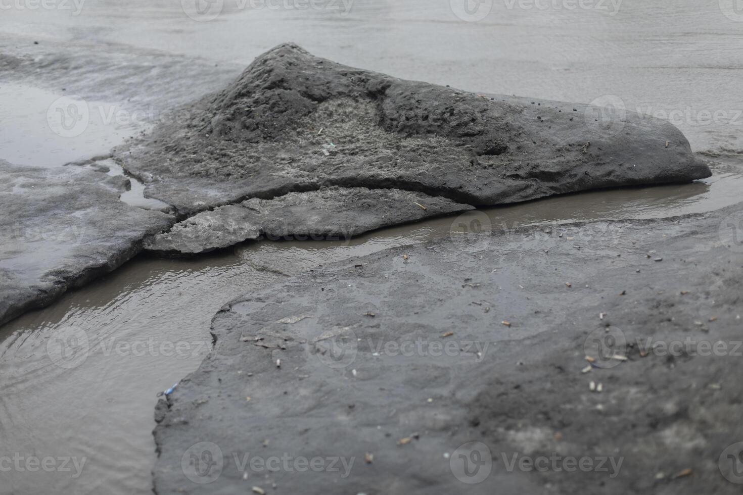 Dirty water flows on asphalt. Flow of water along road. Cloudy liquid. photo